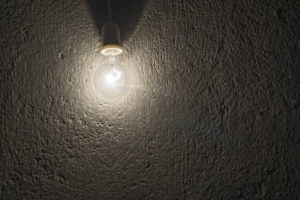 electric bulb on a rough concrete wall